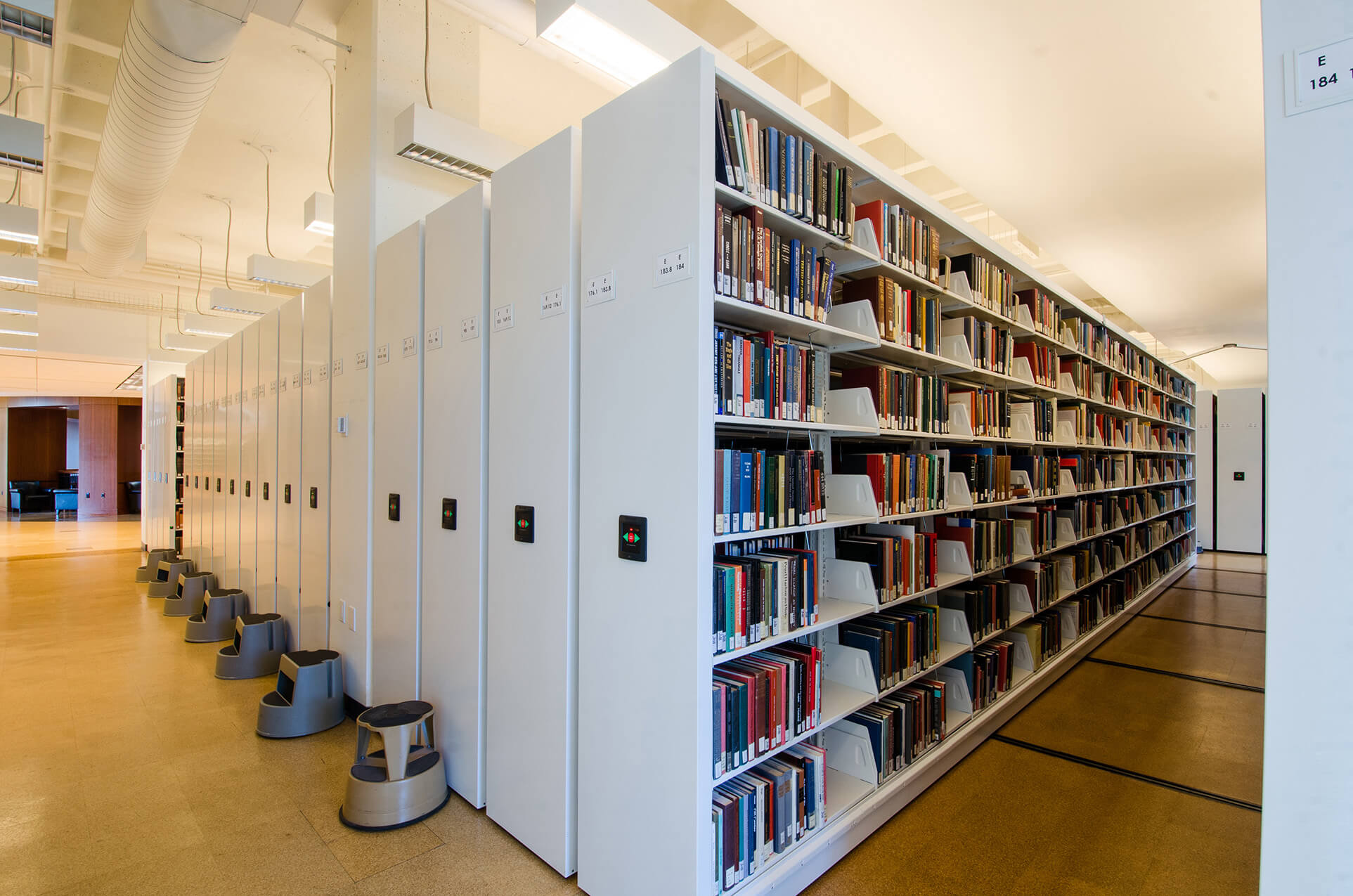 Powered compact mobile shelving for library book storage