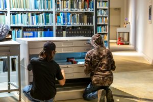 Two Spacesaver Storage Solutions technicians install the Spaceaver Flat File 420 cainet